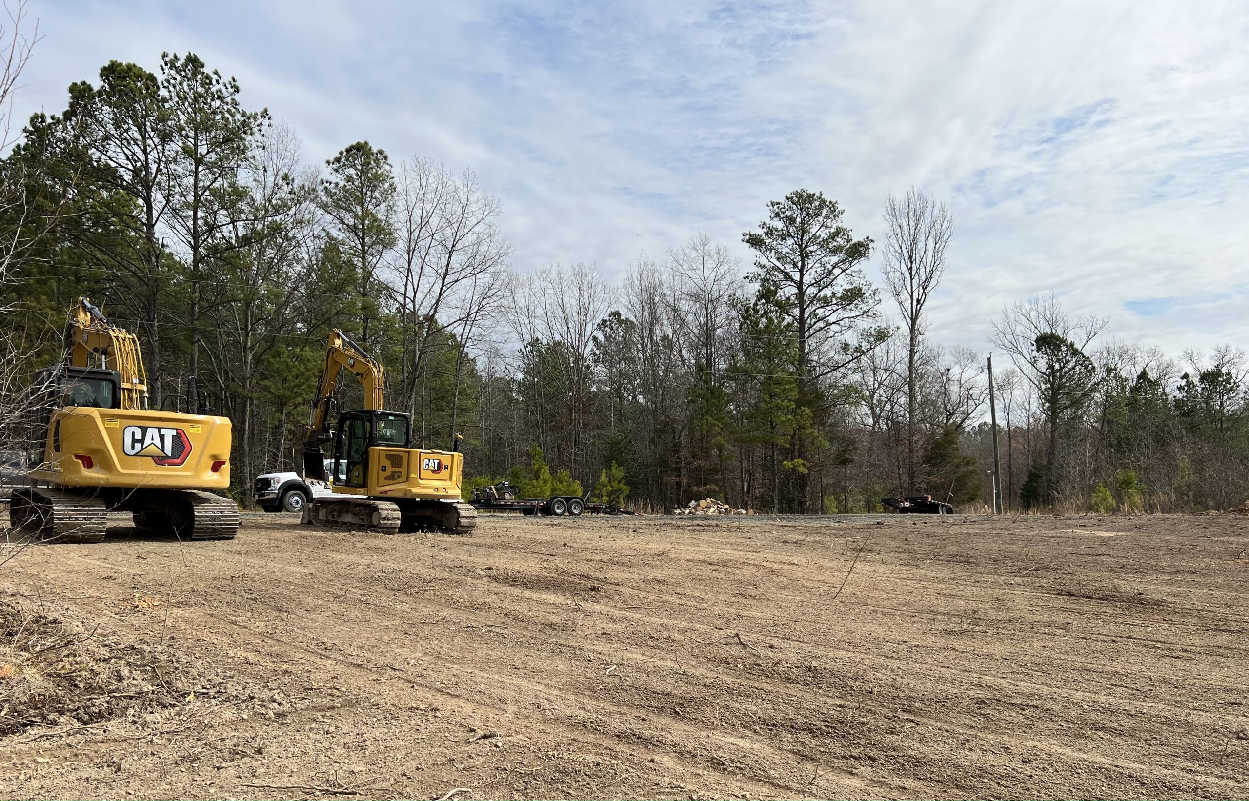 Bulldozer clearing land from old trees, roots and branches with dirt and trash