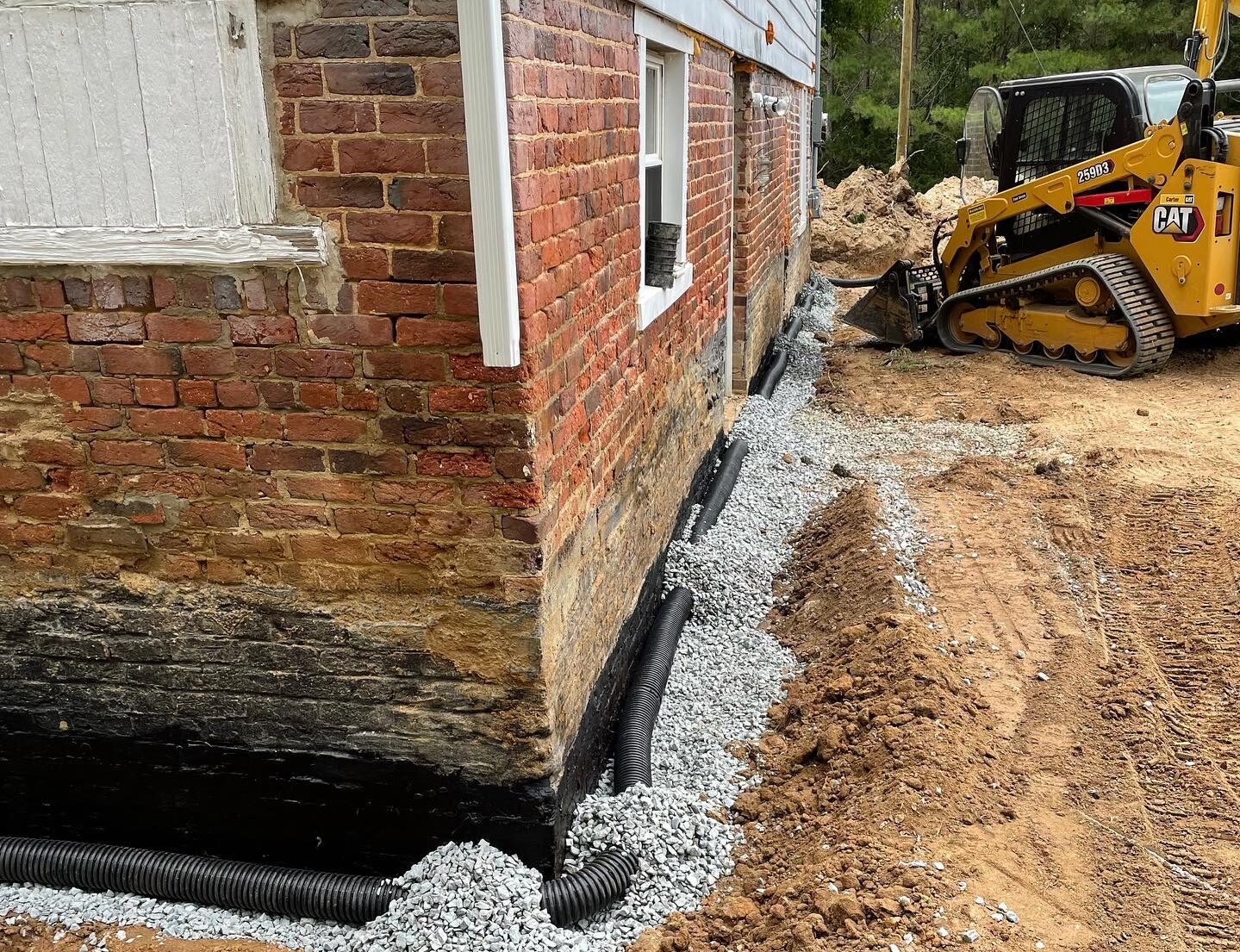 Man installing a drain pipe for powhatan drainage solutions