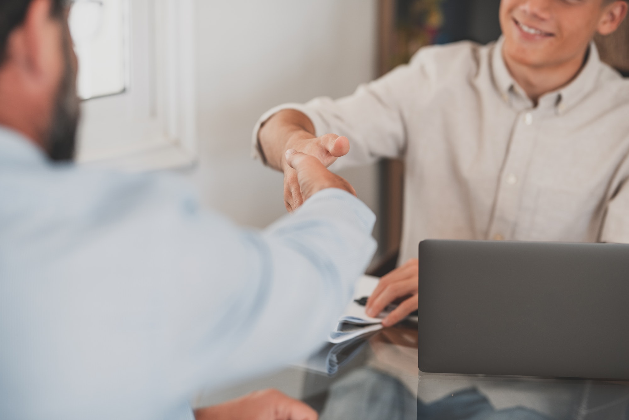 Smiling caucasian teenager hr manager handshake hire male candidate at job interview